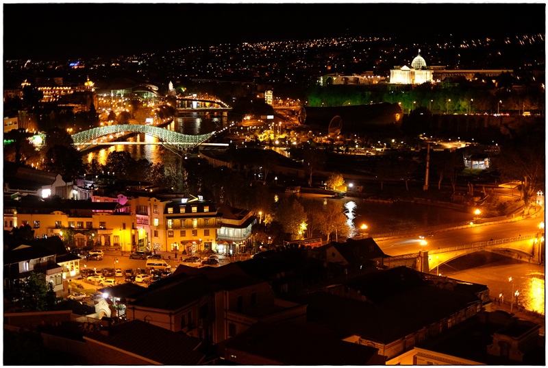 Tbilisi bei Nacht mit Friedensbrücke und Parlament